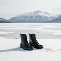 Black boots in the snow with mountains in the background
