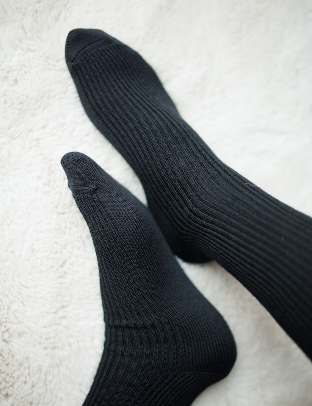 Pair of black socks on a light gray surface