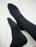 Pair of black socks on a light gray surface